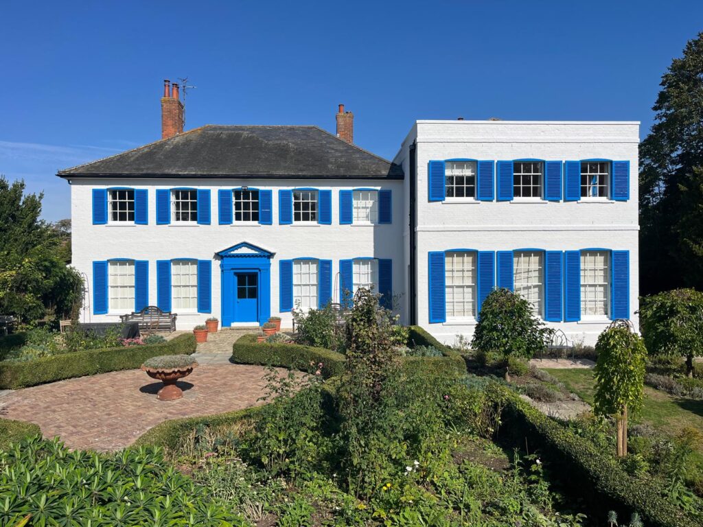 White-painted house with blue doors, windows, and shutters decorated by SM Decorators in Essex