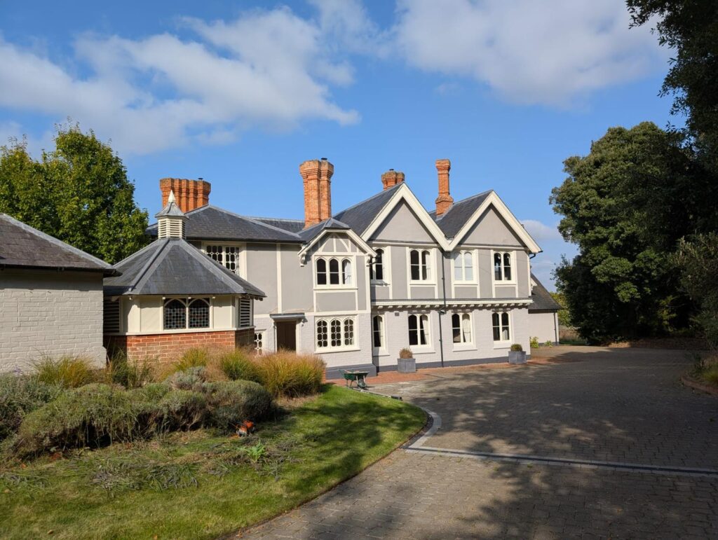 Light grey house with white and dark grey exterior accents painted by SM Decorators in Essex